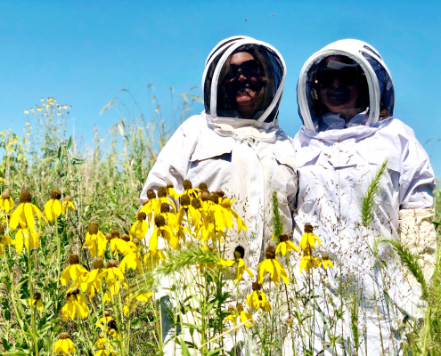 two women in beekeeper suits